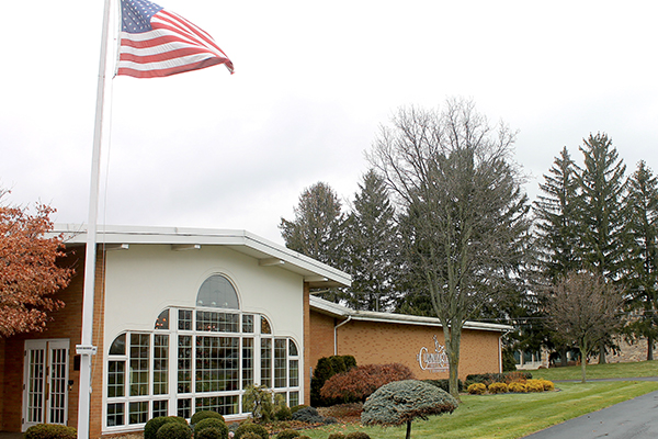Building with large windows and an American flag flying outside on a cloudy day