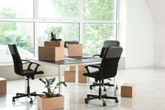 Cardboard boxes with belongings and furniture in new office