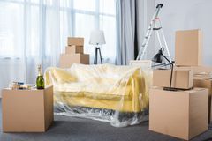 Empty living room with couch and stacks of boxes