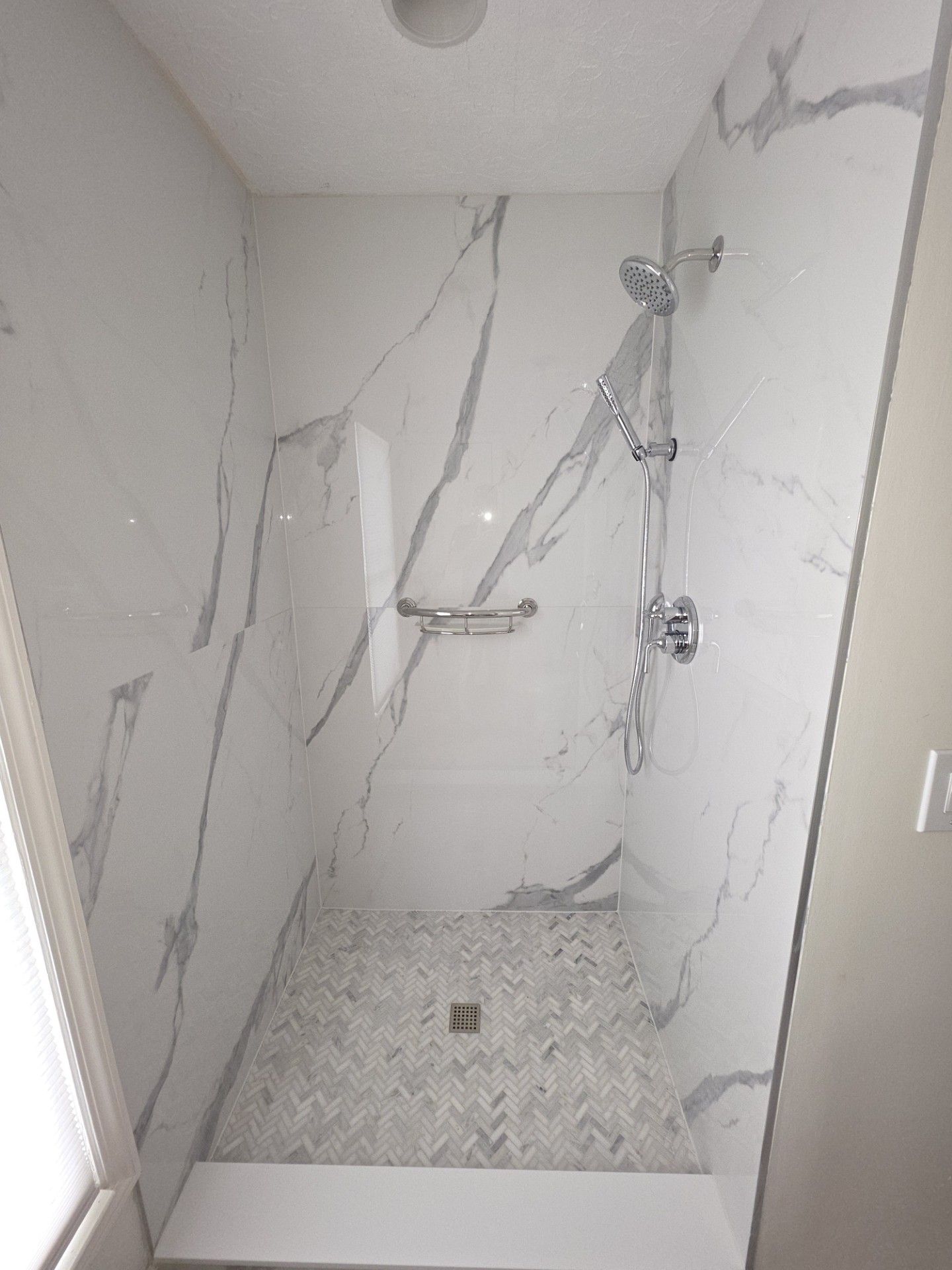Bright white bathroom with double vanity, large mirror, and tiled tub-shower combo.