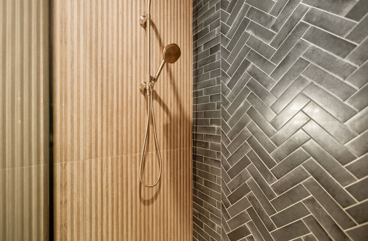 Modern bathroom with a bathtub, walk-in shower, and double sink vanity in gray tile tones