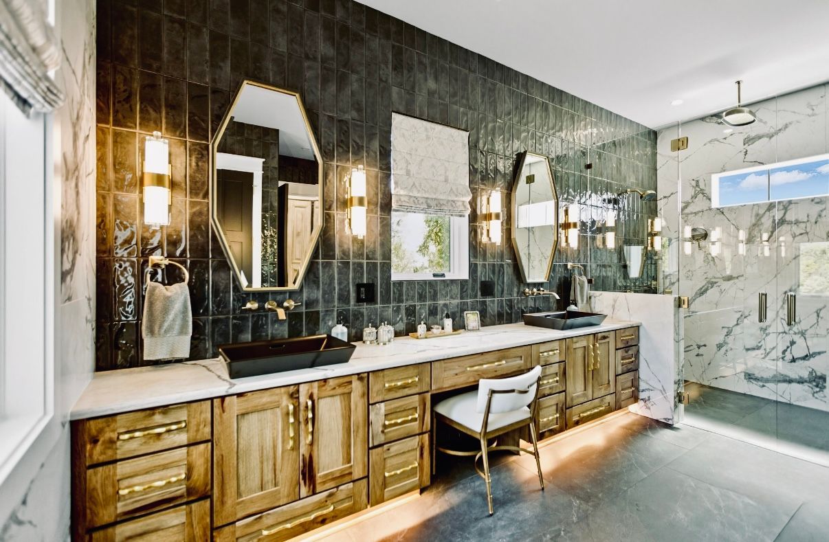 Bathroom under renovation with black waterproofed shower walls, ladder, and vanity sink in foreground