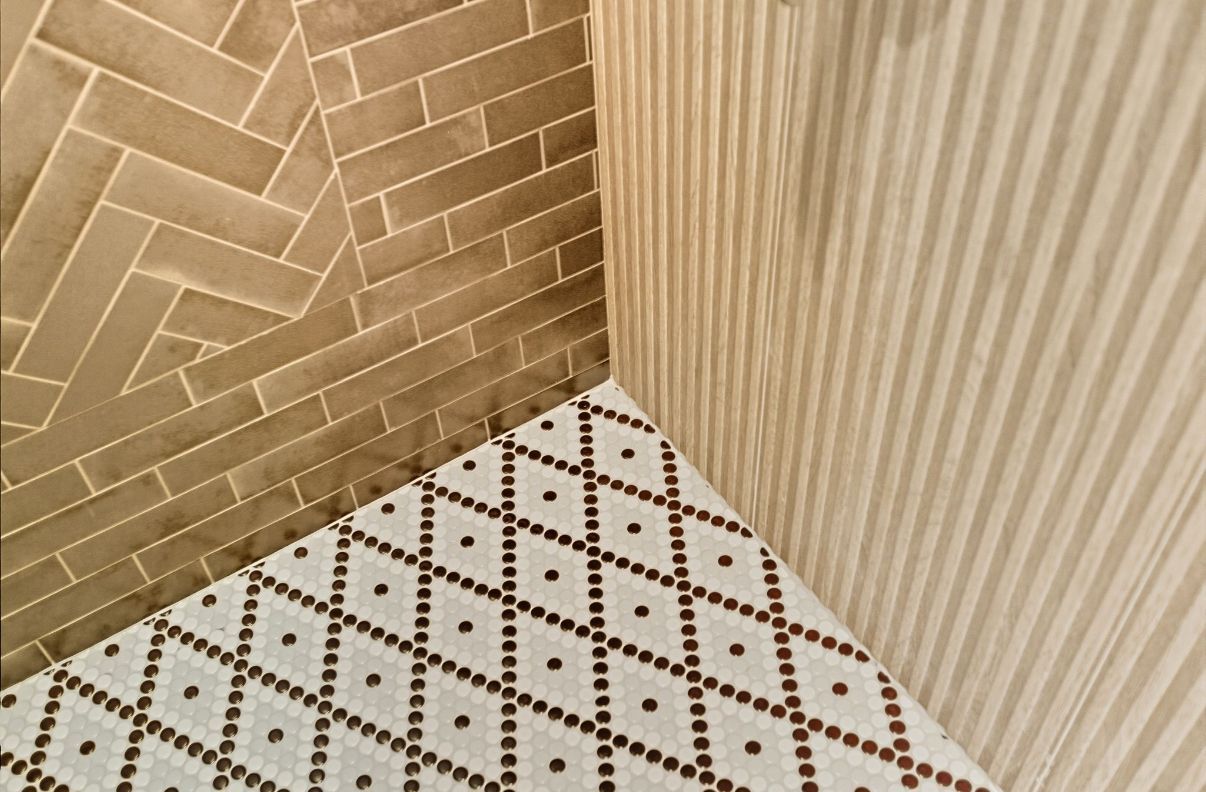Hands installing white geometric wall panels with exposed adhesive and tools visible