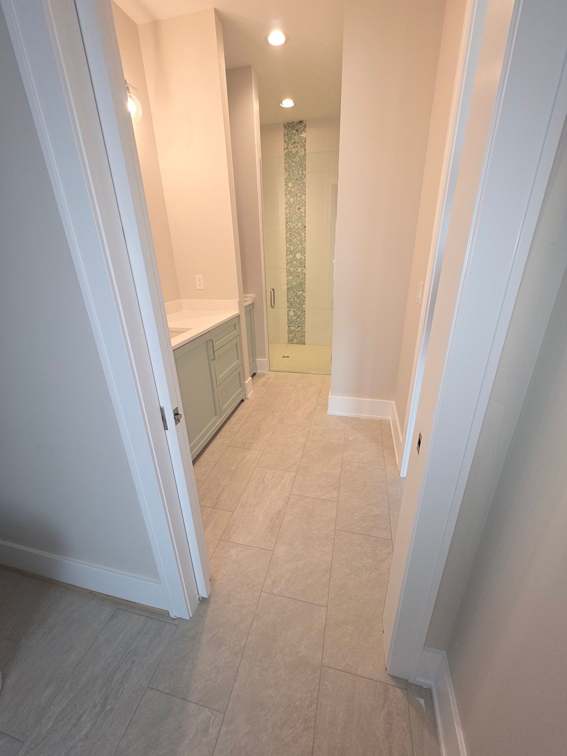 Person installing light wood flooring with a trowel over adhesive underlayment.