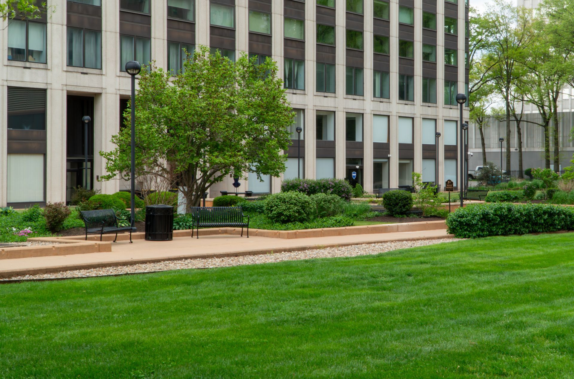 Office building with manicured green lawn and shrubs in front Office building with manicured green lawn and shrubs in front