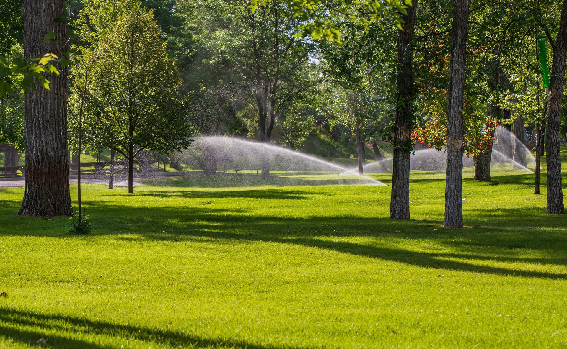 Lush landscaped lawn with irrigation spray for a free estimate on inspection services