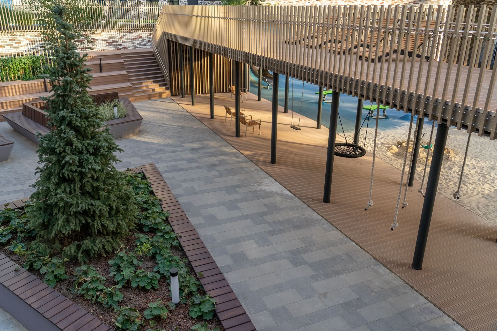 Modern outdoor courtyard with curved walkway, planters, and a shaded wooden pergola over seating area Modern outdoor courtyard with curved walkway, planters, and a shaded wooden pergola over seating area