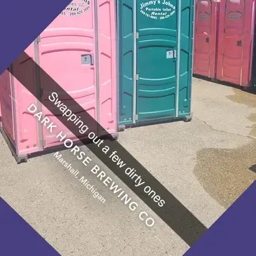 A picture of pink and green portable toilets from dark horse brewing co.