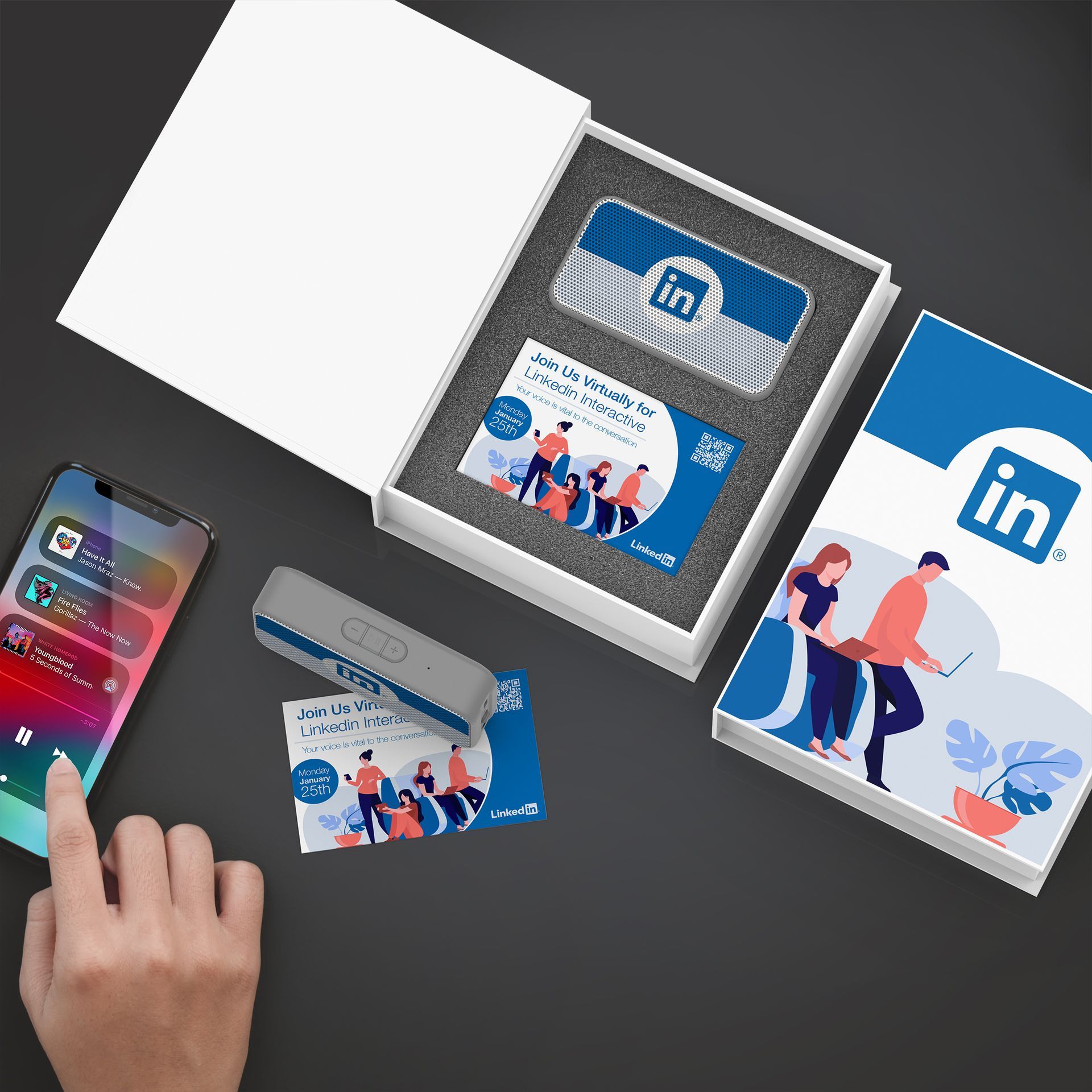 A person is using a cell phone next to a box of business cards.