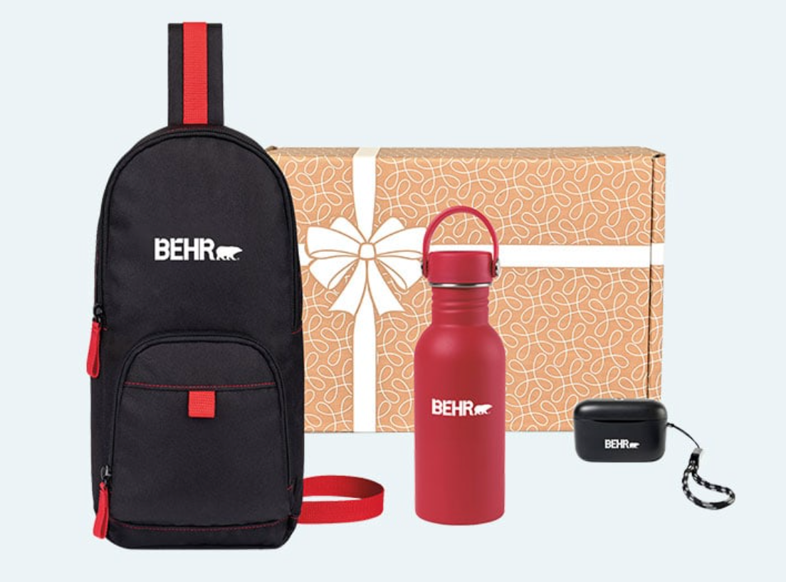 A red water bottle , a black backpack , and a box with a bow on it.