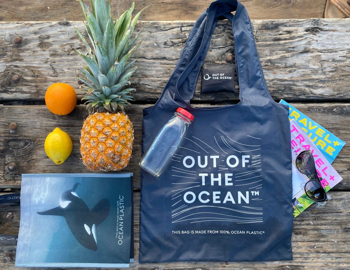 A blue tote bag with the words out of the ocean on it