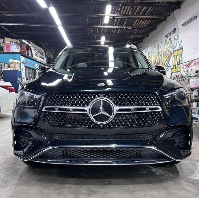 Black Mercedes-Benz SUV front view in a garage, with chrome grille and star emblem.