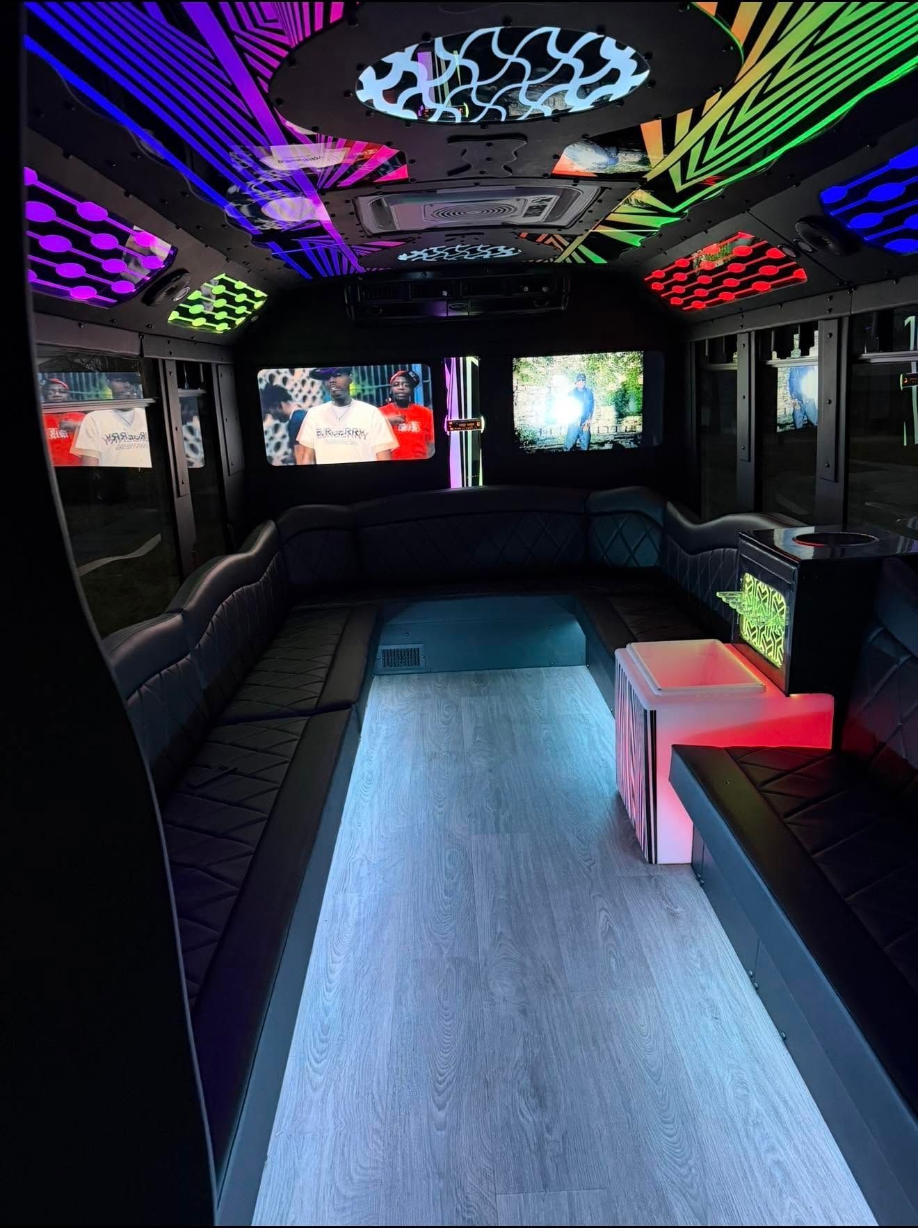 Neon-lit party bus interior with black leather benches, a central aisle, and glowing ceiling and wall lights