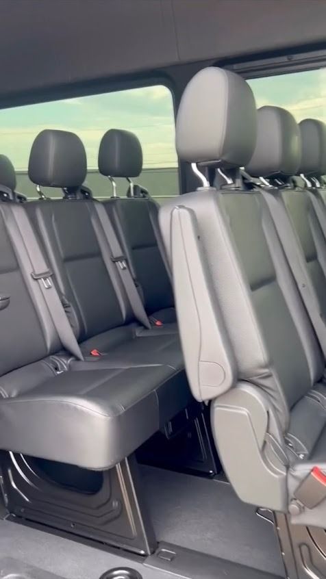 Gray van interior with multiple rows of black seats and headrests