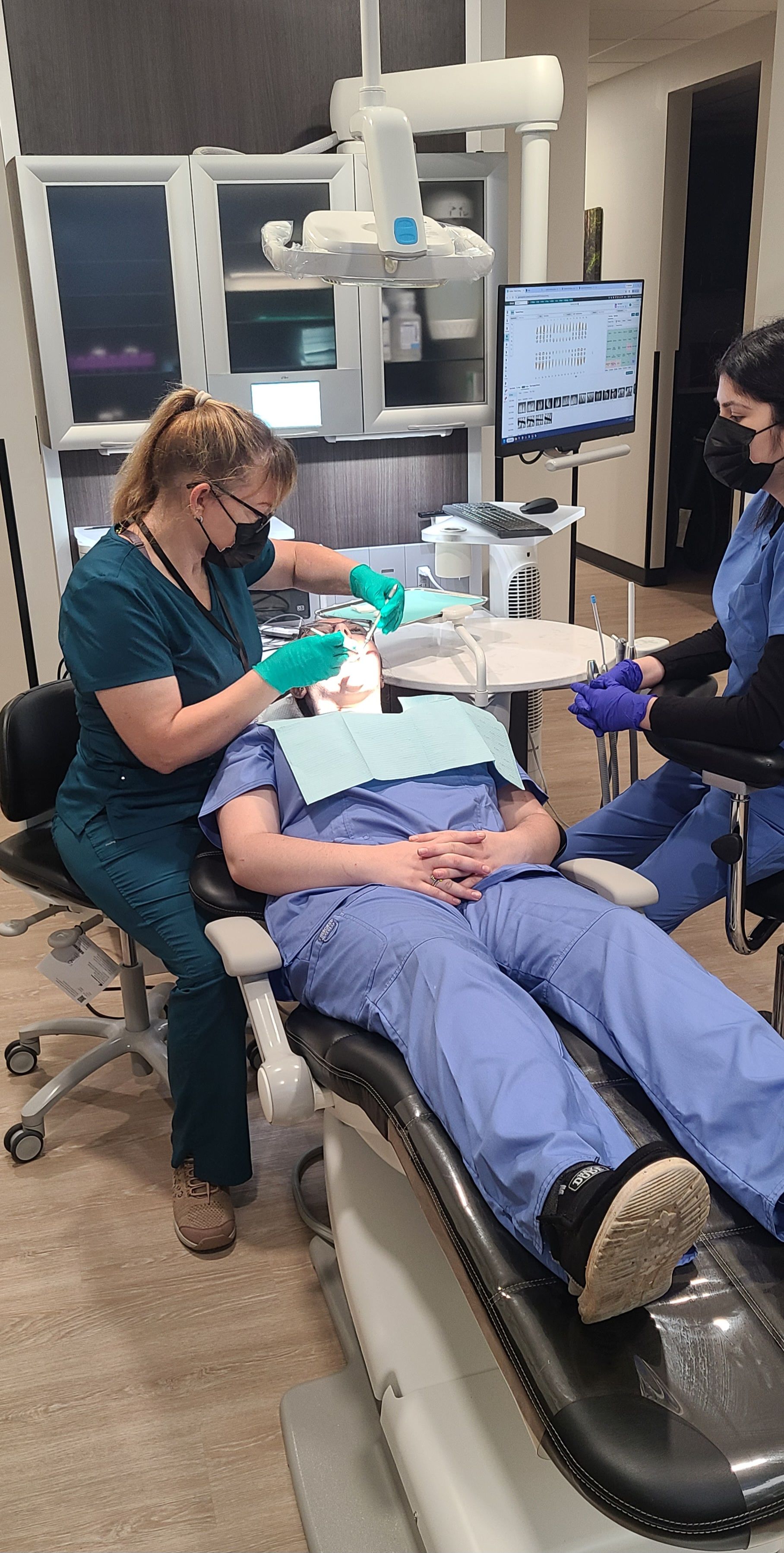 Dental assisting students suctioning in mouth
