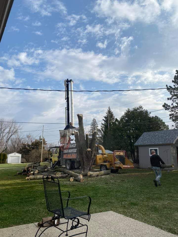 Construction equipment drilling a yard, with a worker walking nearby under a cloudy sky.