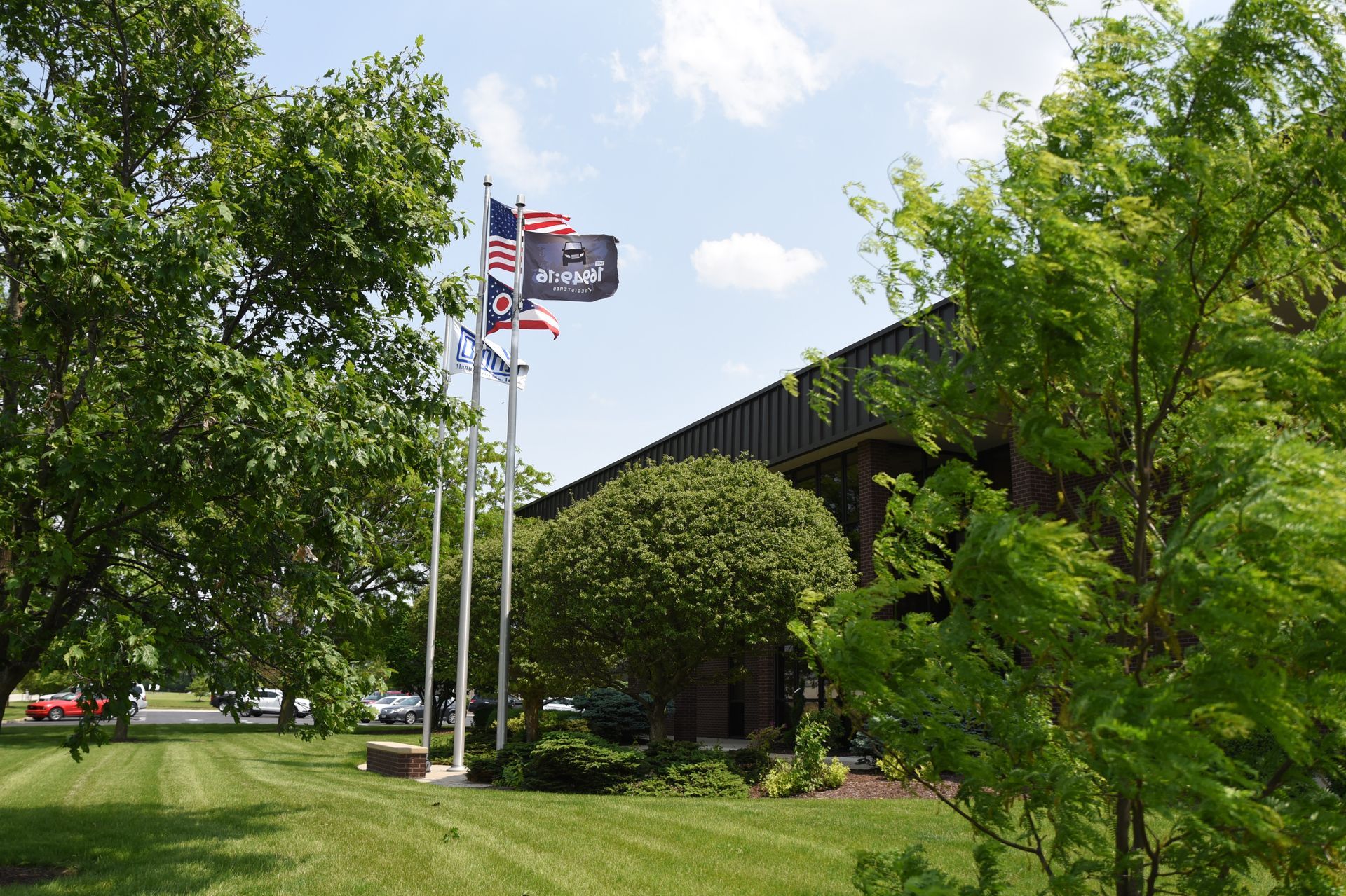 A row of flags are flying in front of a buildingOmni IATF certification