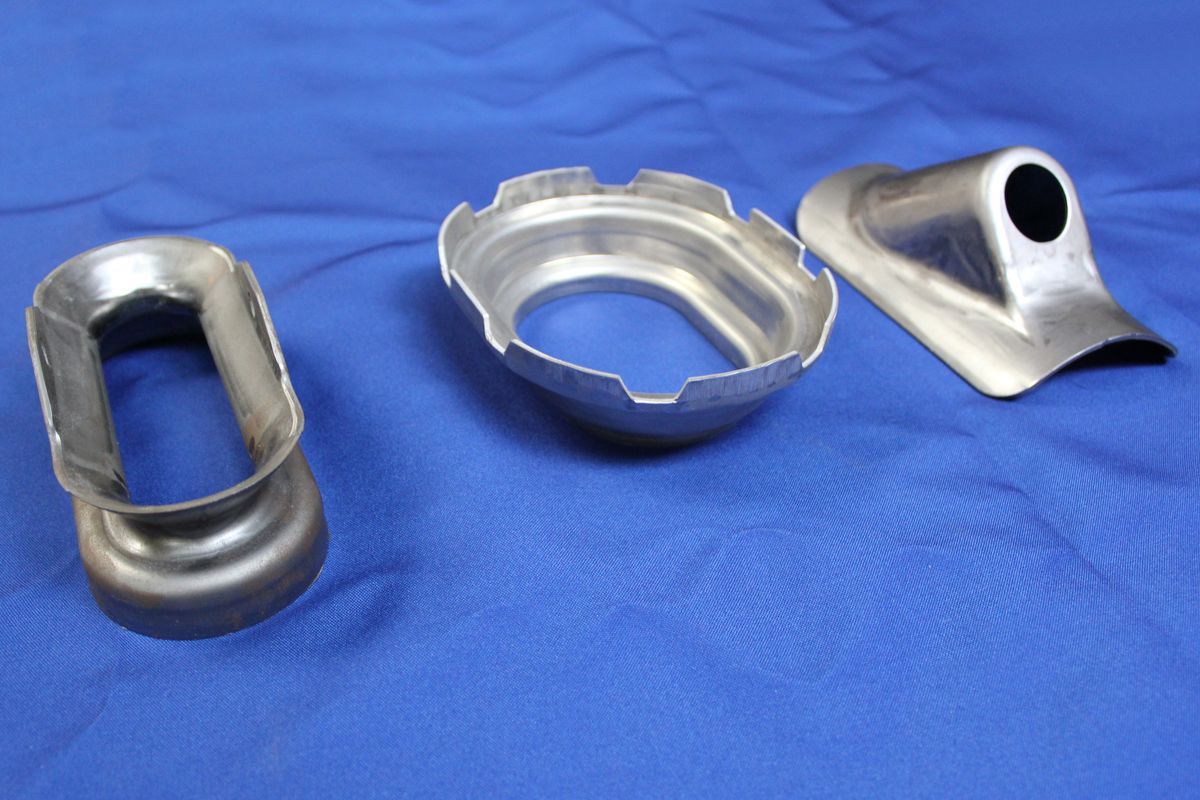 Three metal pieces are sitting on a blue cloth