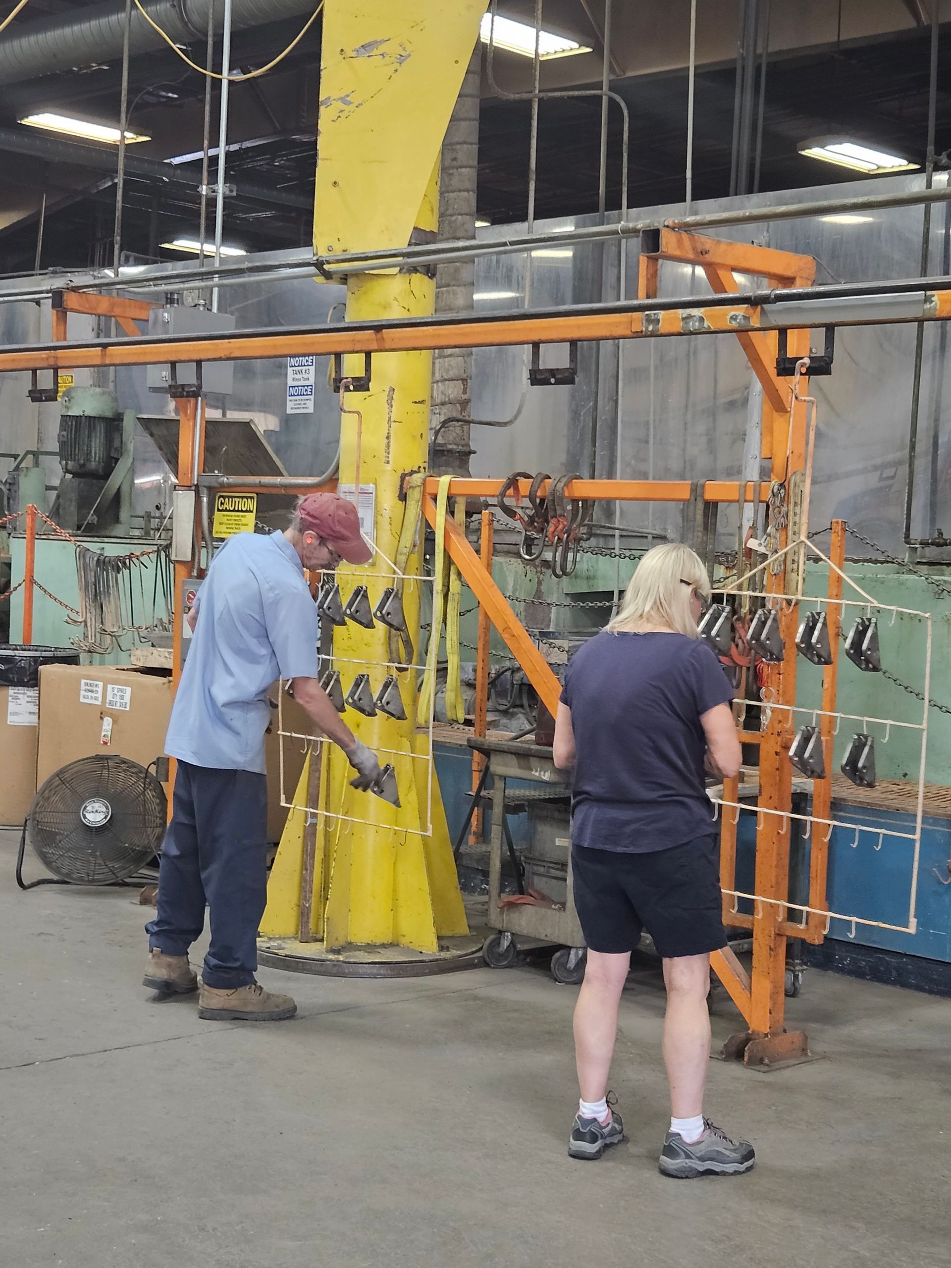 A man and a woman are working in a factory