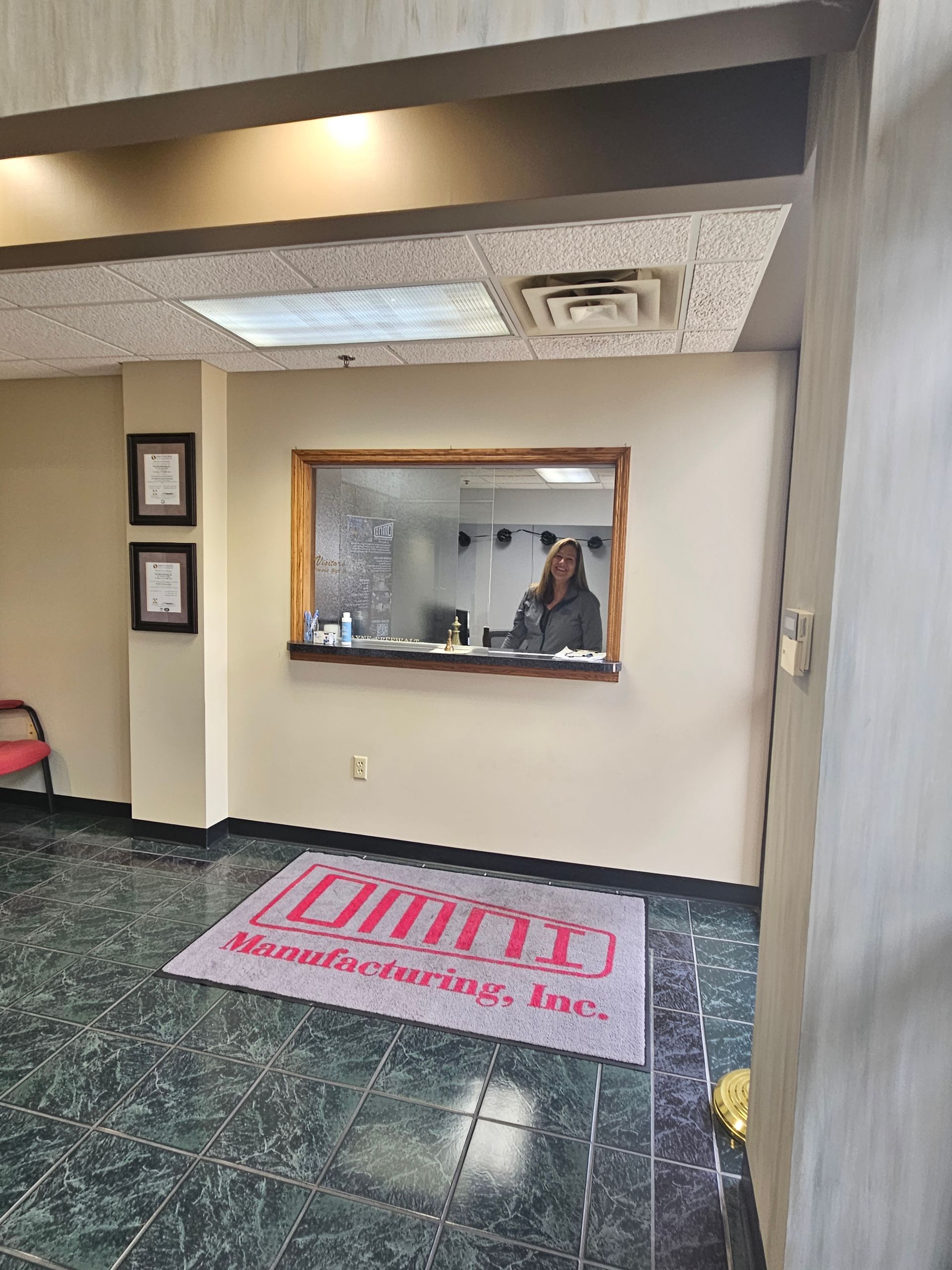 A woman is standing in a waiting room in front of a window.