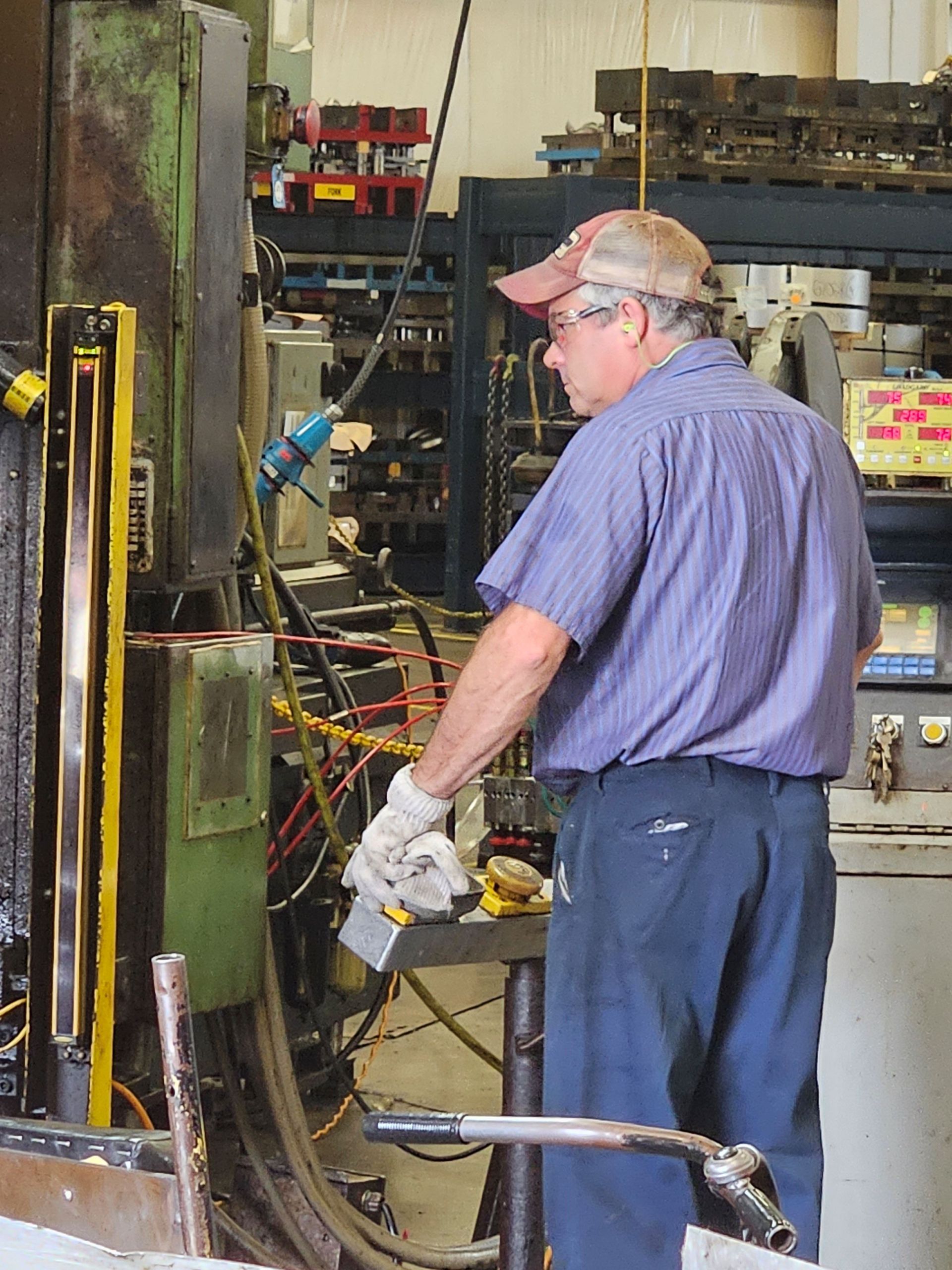 A man in a purple shirt is working on a machine