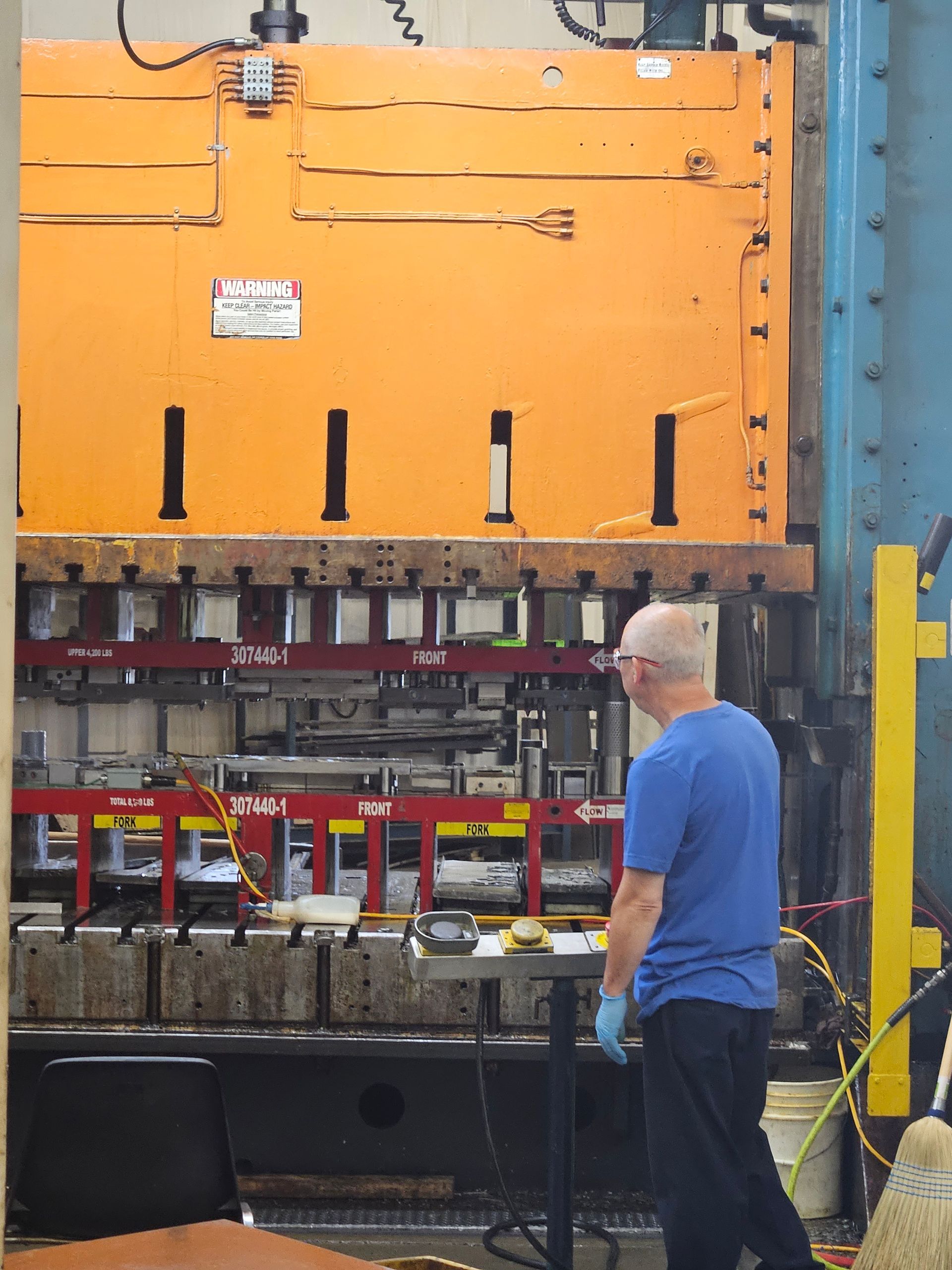 A man in a blue shirt is working on a machine