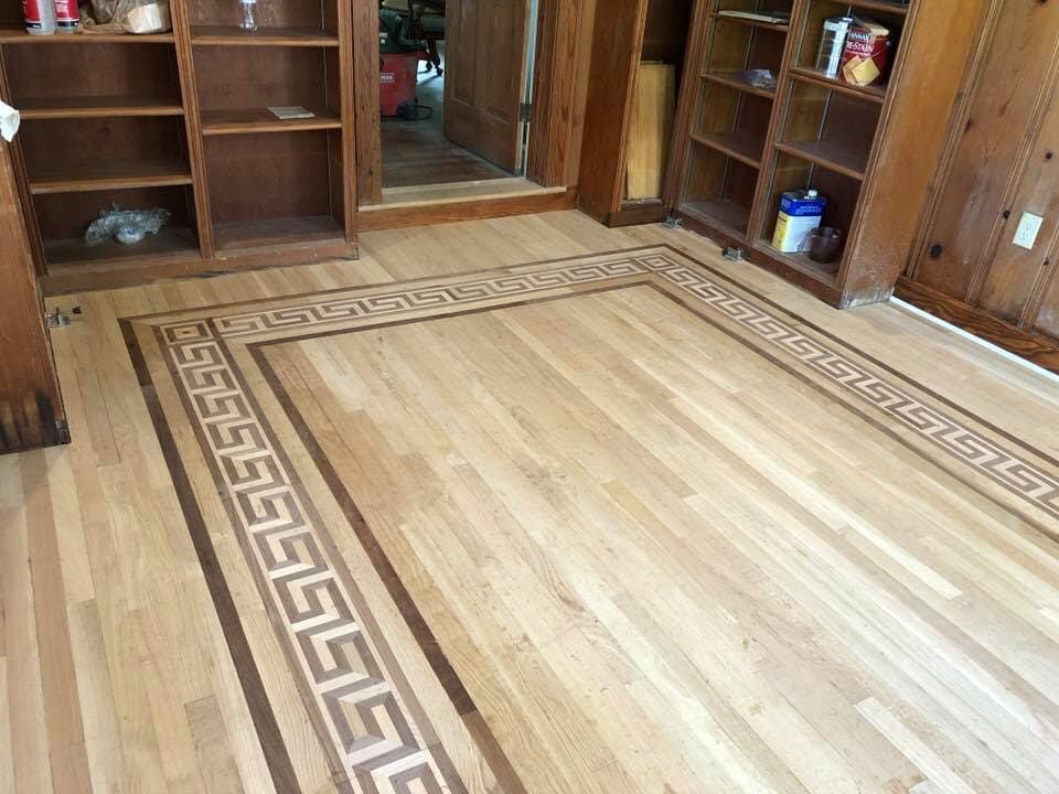 A wooden floor with a greek key pattern on it