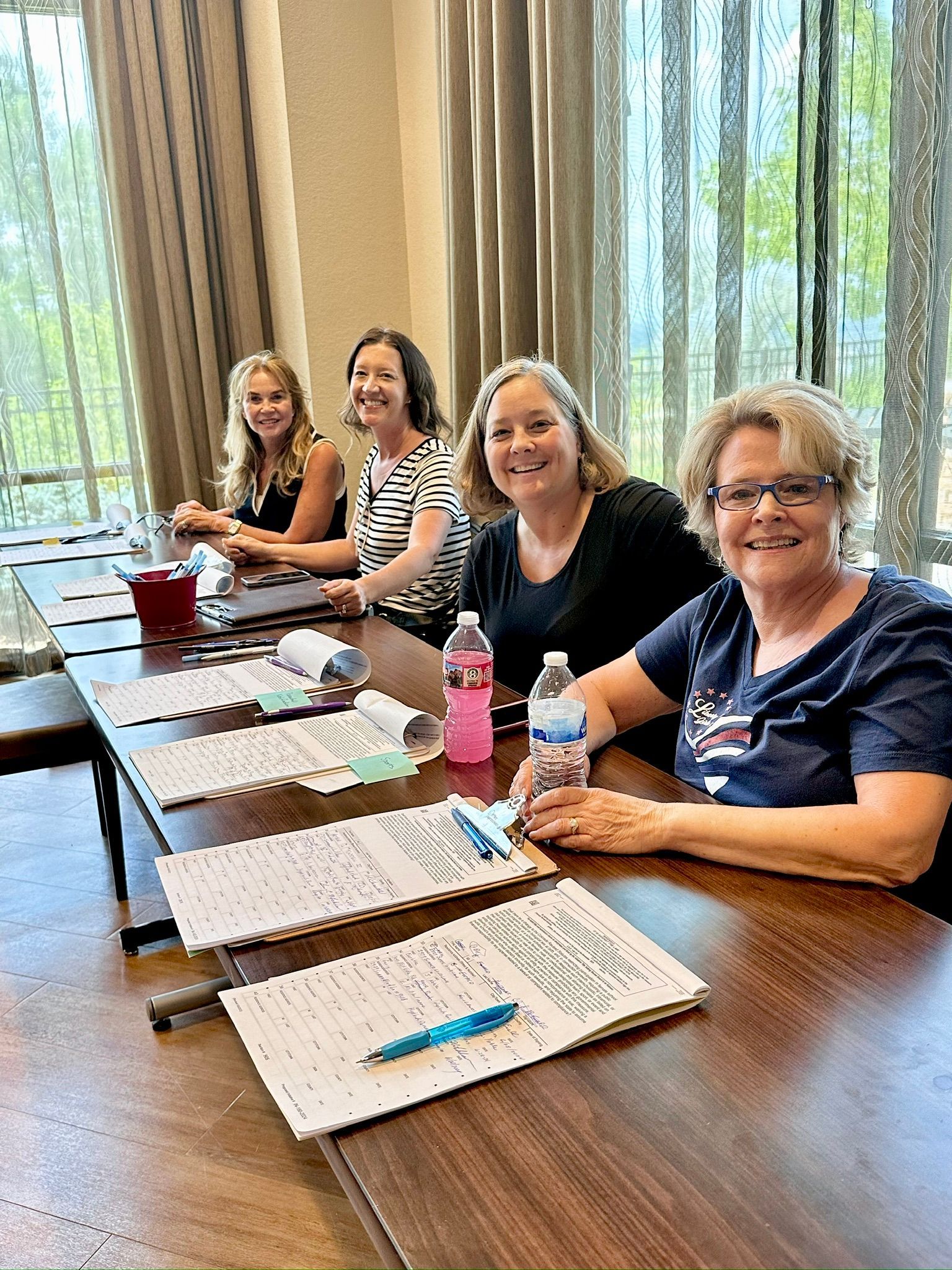 A group of women are sitting at a long table.