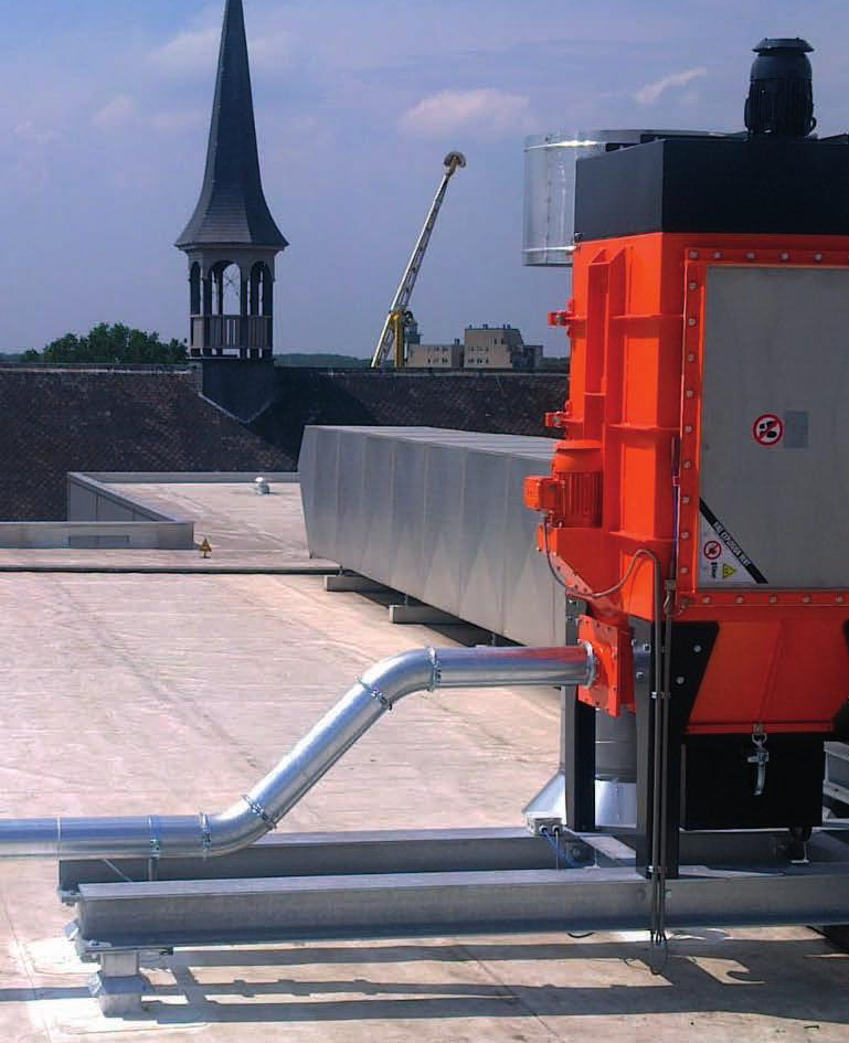Dakventilatie-unit met zilverkleurige leidingen naast een kerktoren en op de achtergrond een kraan.