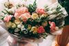 Pastel bouquet of pink, cream, and white flowers wrapped in white paper
