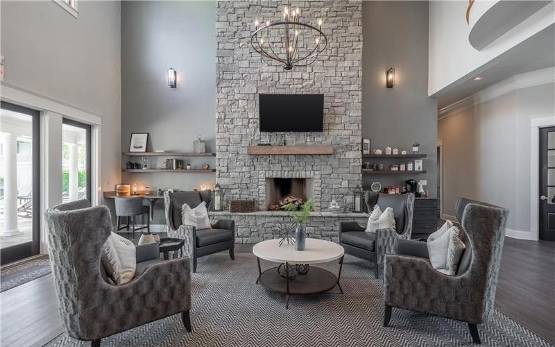 Stone fireplace, armchairs, and a round coffee table.