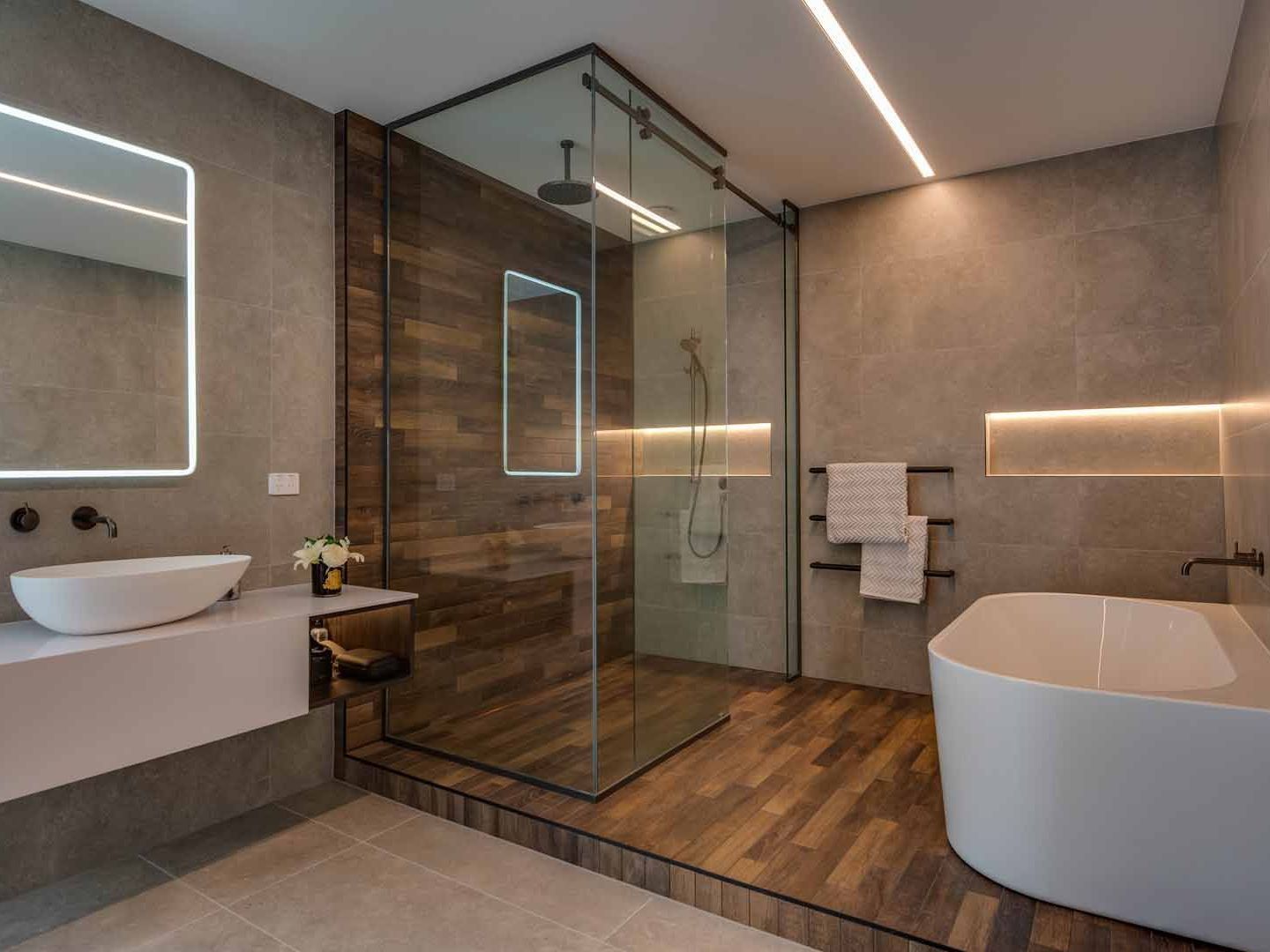 A bathroom with a walk in shower , bathtub , sink and mirror.