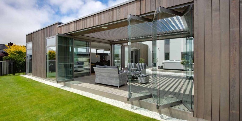 A modern house with a patio and sliding glass doors.