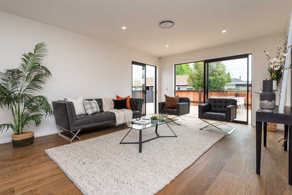A living room with a couch , chair , coffee table and rug.