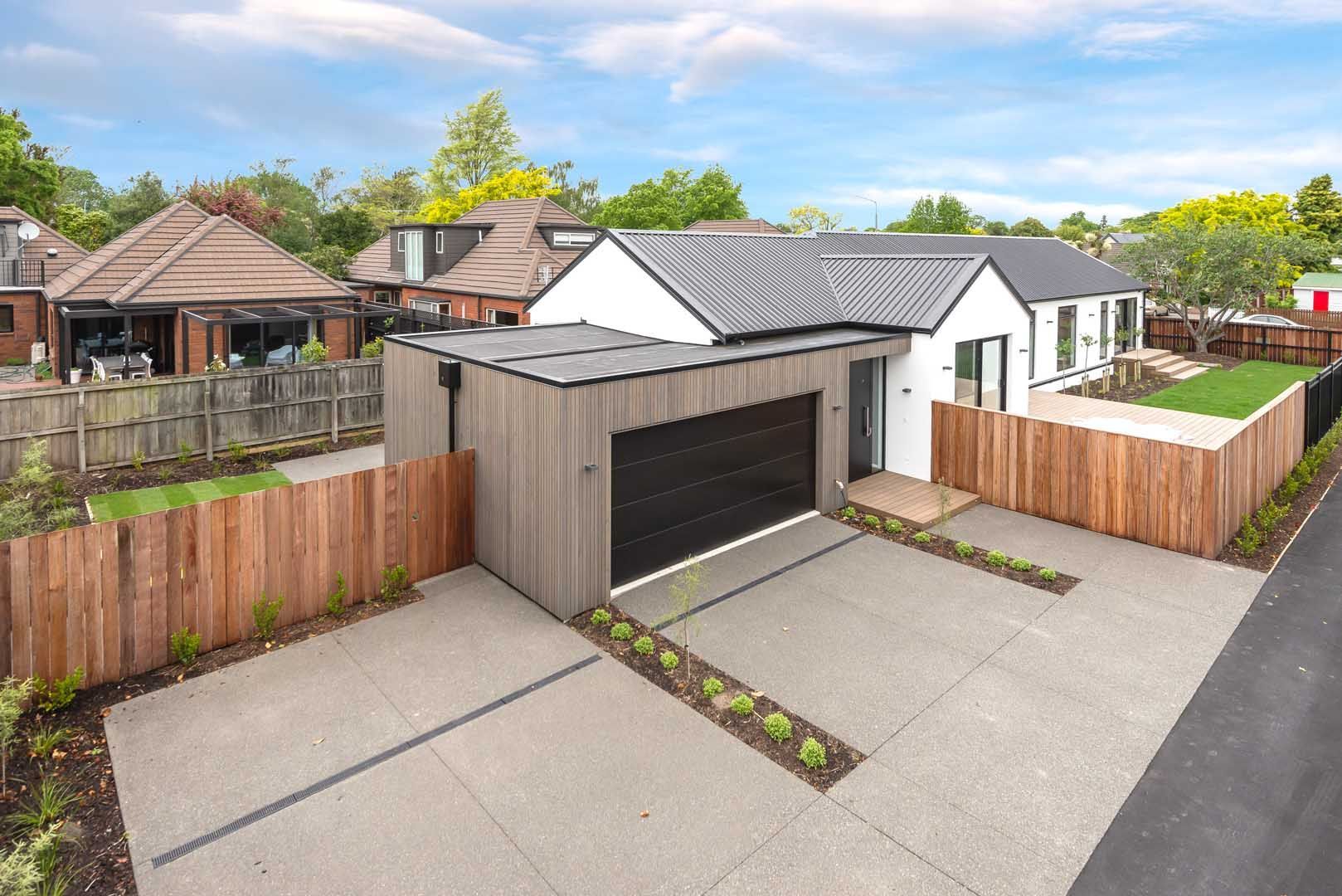 An aerial view of a house with a garage and a wooden fence