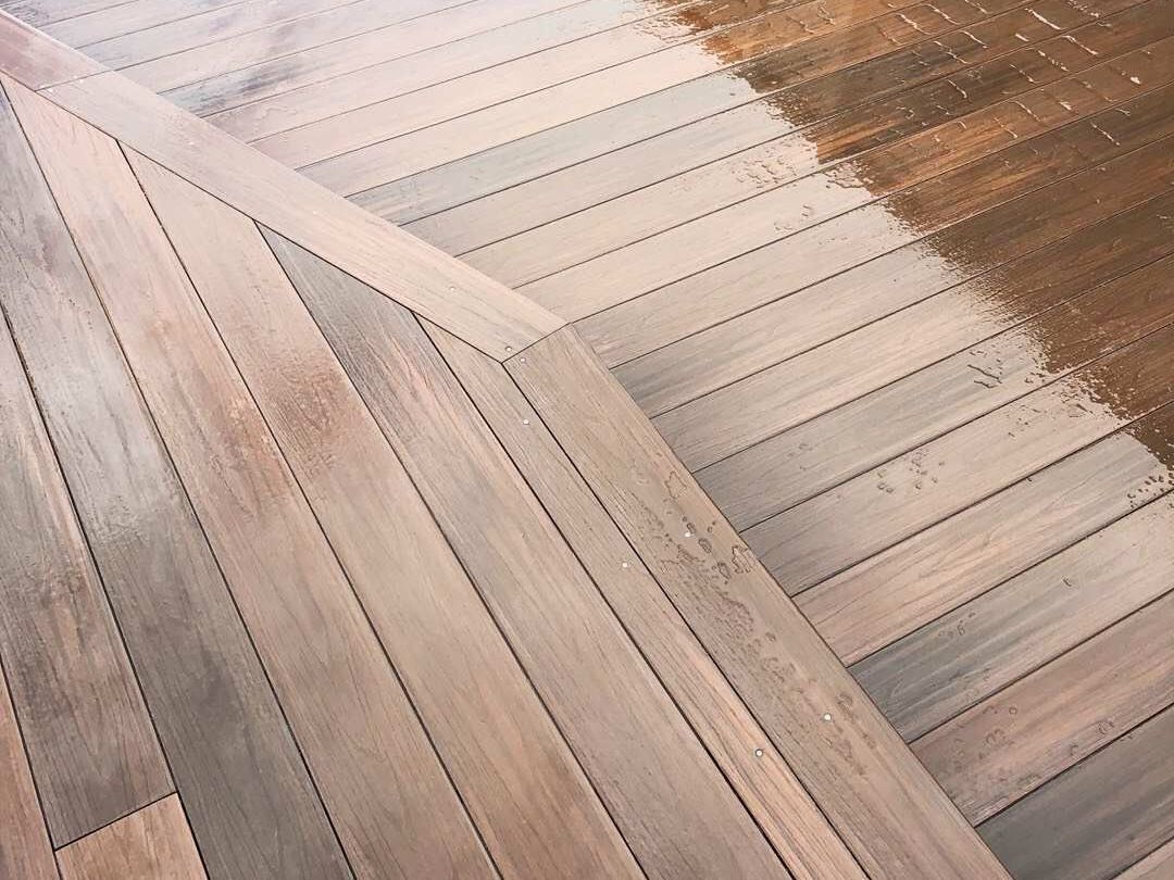 a wooden deck is being cleaned by a person