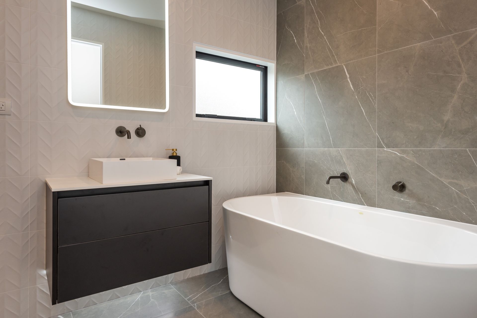 a bathroom with a bathtub sink and mirror