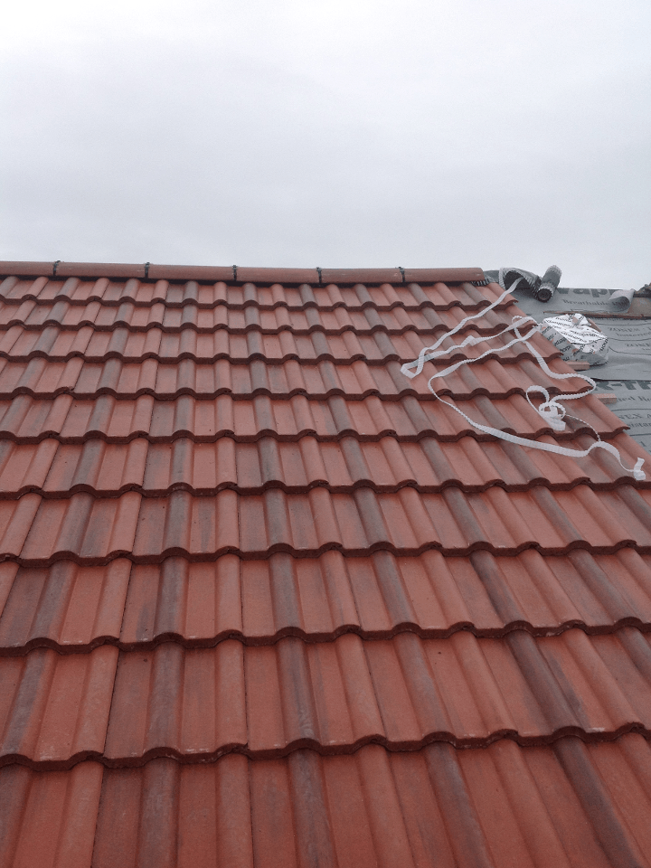 Picture of a mid terrace roof with bonding gutter replaced in Red concrete tile by Roofers Nottingham
