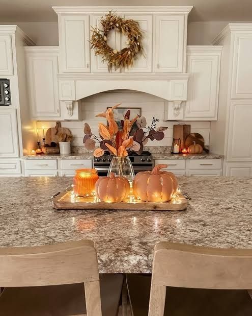 Kitchen decorated for fall with pumpkin decor and a floral wreath.