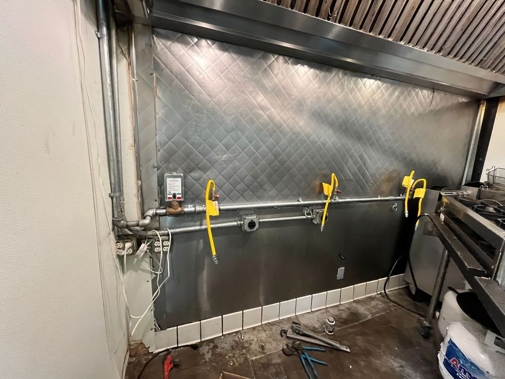 A kitchen with a stainless steel hood and a stove.