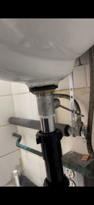 A sink with a drain underneath it in a bathroom.