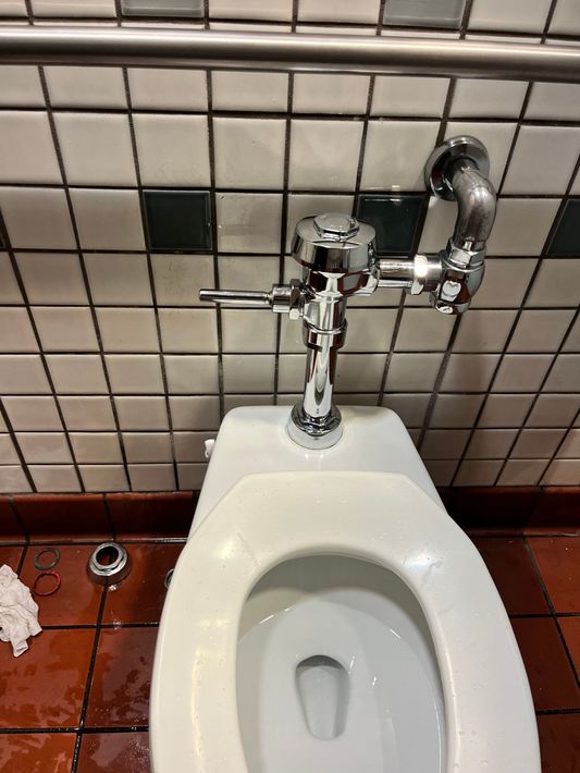 A close up of a toilet in a public restroom