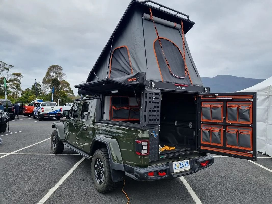 Green Camping Truck With Rooftop Tent and Open Rear Storage in a Parking Lot — Kingston 4wd and Tyres In Huntingfield, TAS