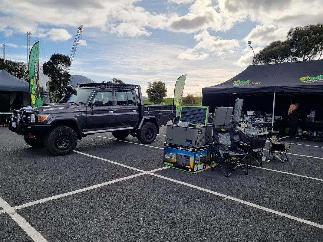 Black Off-road Truck and Camping Gear Displayed at an Outdoor Event Under Cloudy Skies — Kingston 4wd and Tyres In Huntingfield, TAS