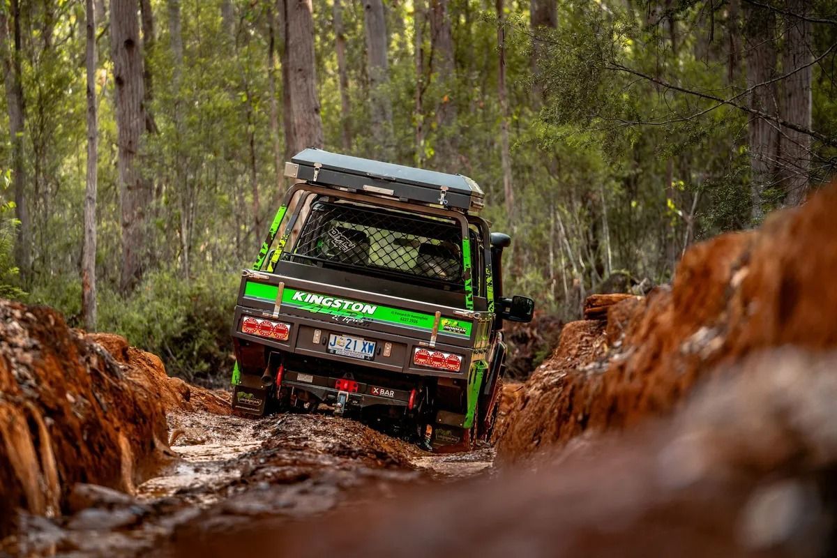 Off-road Truck Crawling Through a Muddy Forest Trail With Trees on Both Sides — Kingston 4wd and Tyres In Huntingfield, TAS