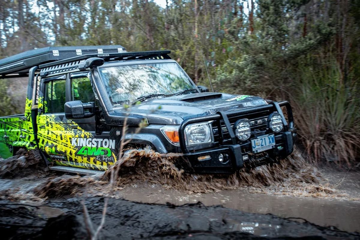 Black Off-road Truck Splashing Through Muddy Water in a Forest — Kingston 4wd and Tyres In Huntingfield, TAS