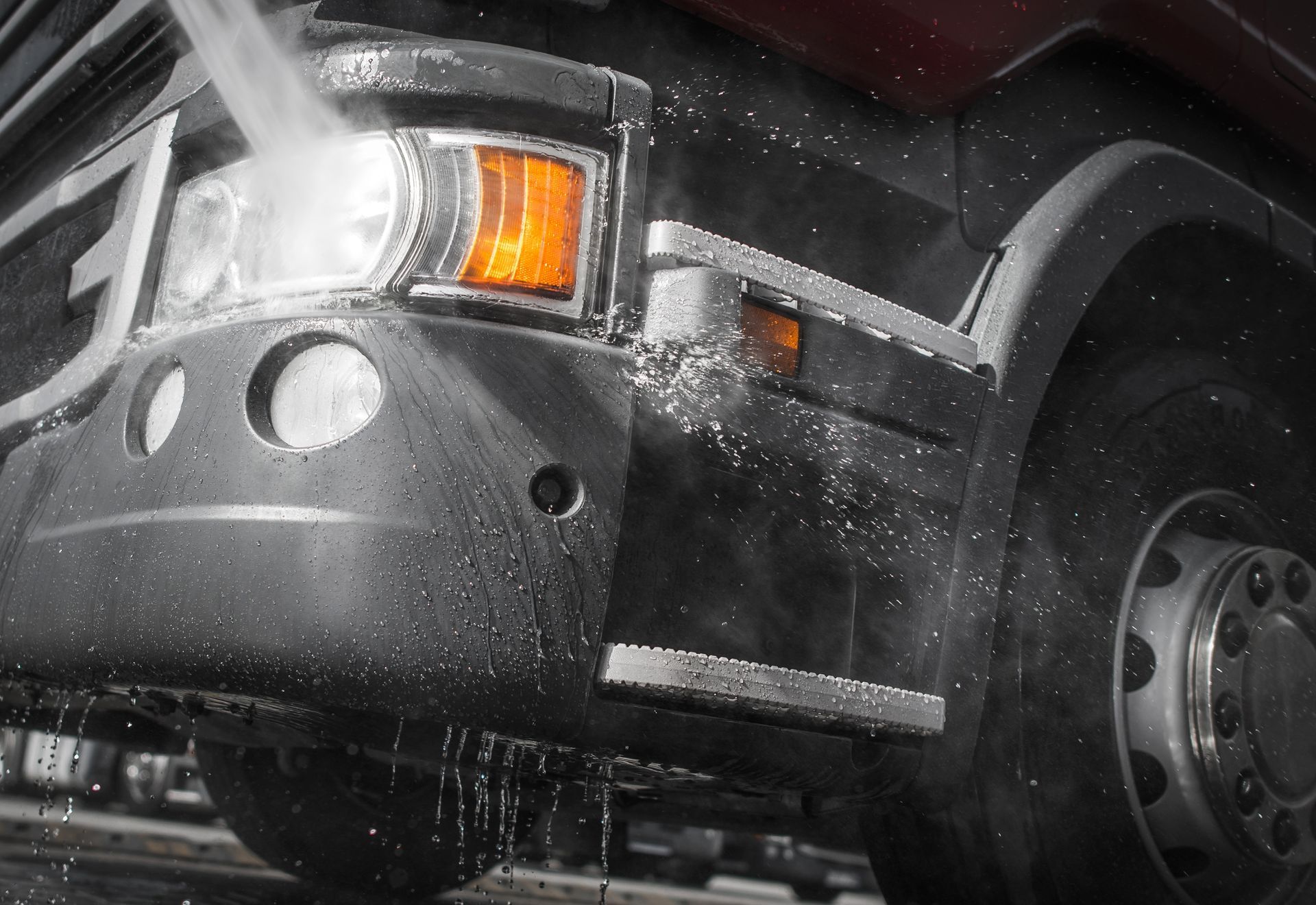 A truck is being cleaned with a high pressure washer
