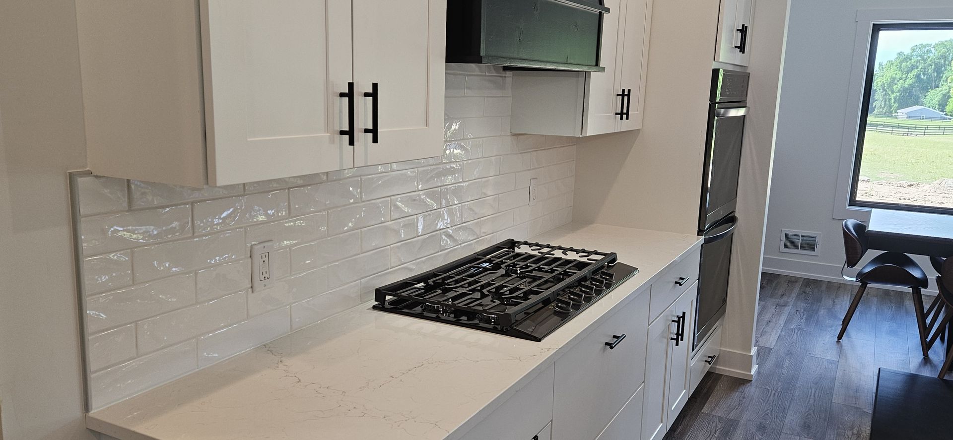 White kitchen with cabinets, stove, and tile backsplash.