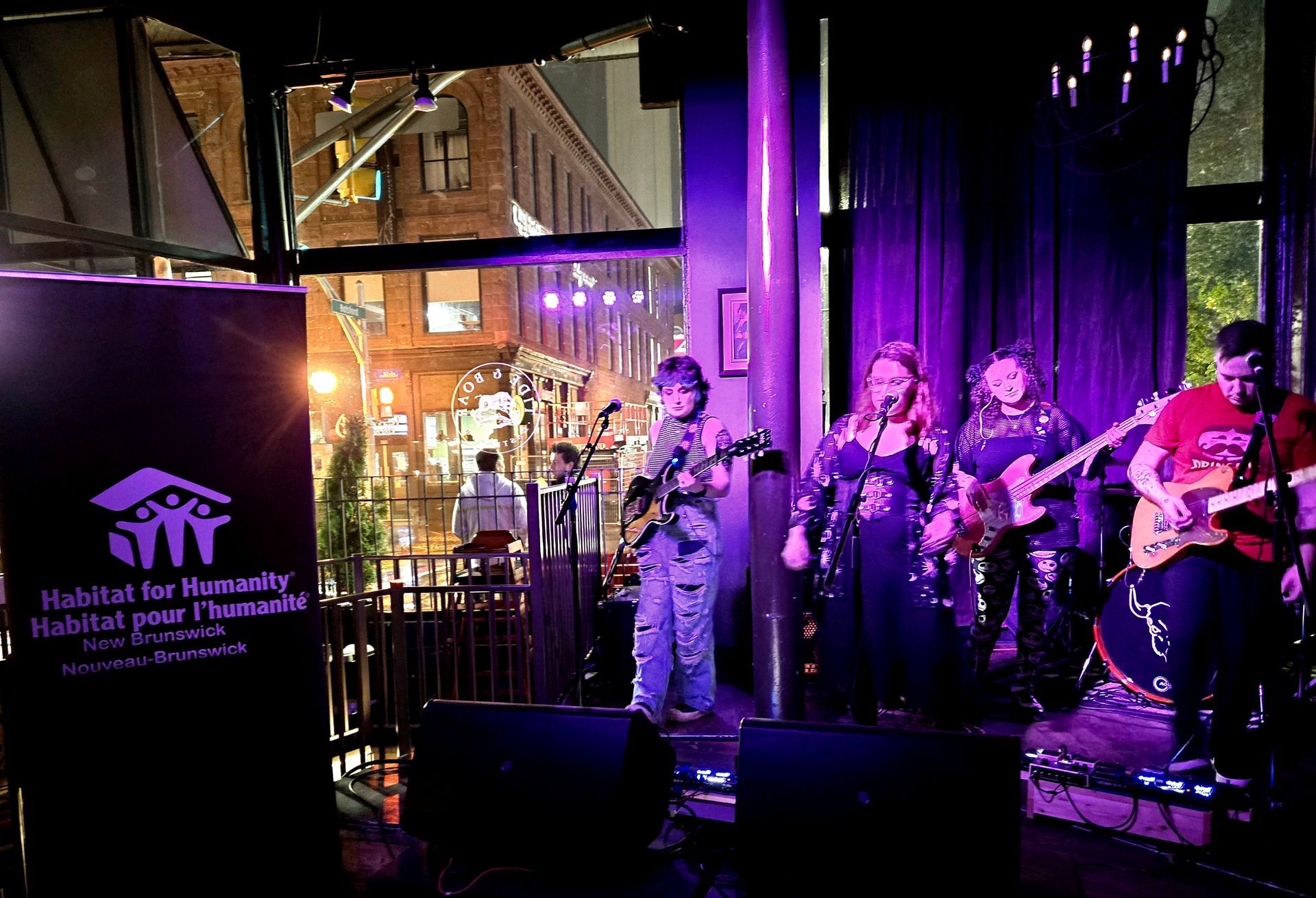 Band performing on a purple-lit stage at Tide and Boar Gastropub, Habitat New Brunswick event
