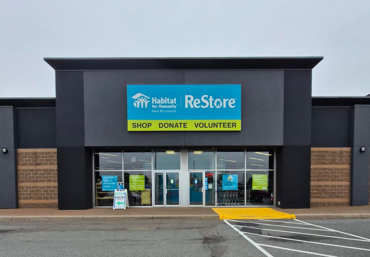 Saint John Habitat for Humanity ReStore storefront with blue signage and “Shop Donate Volunteer” banner